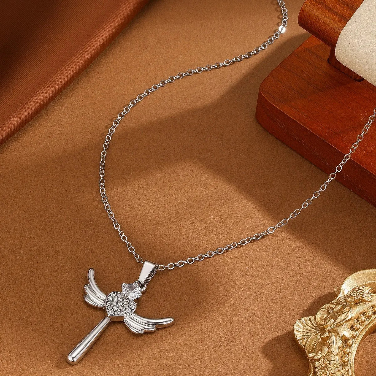 Silver heart-shaped angel wings pendant clavicle chain necklace with cross elements on display