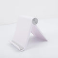 Folding plastic desktop stand holding a smartphone in black colour on a desk