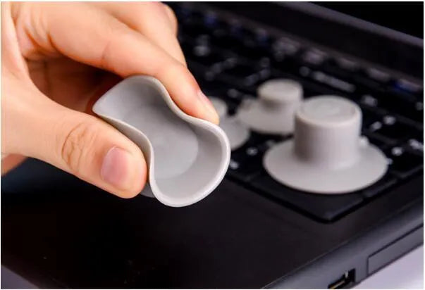 Grey plastic laptop cooling pad set showing two large and two small pads on a wooden desk.