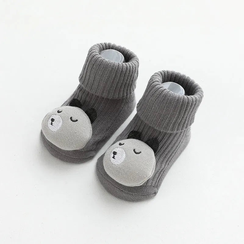 Pair of light grey baby socks with white non-slip silicone grip dots on the soles.