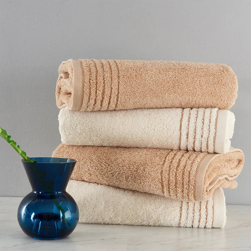 Set of three cotton towels in beige and brown including large bath towel, hand towel, and small washcloth