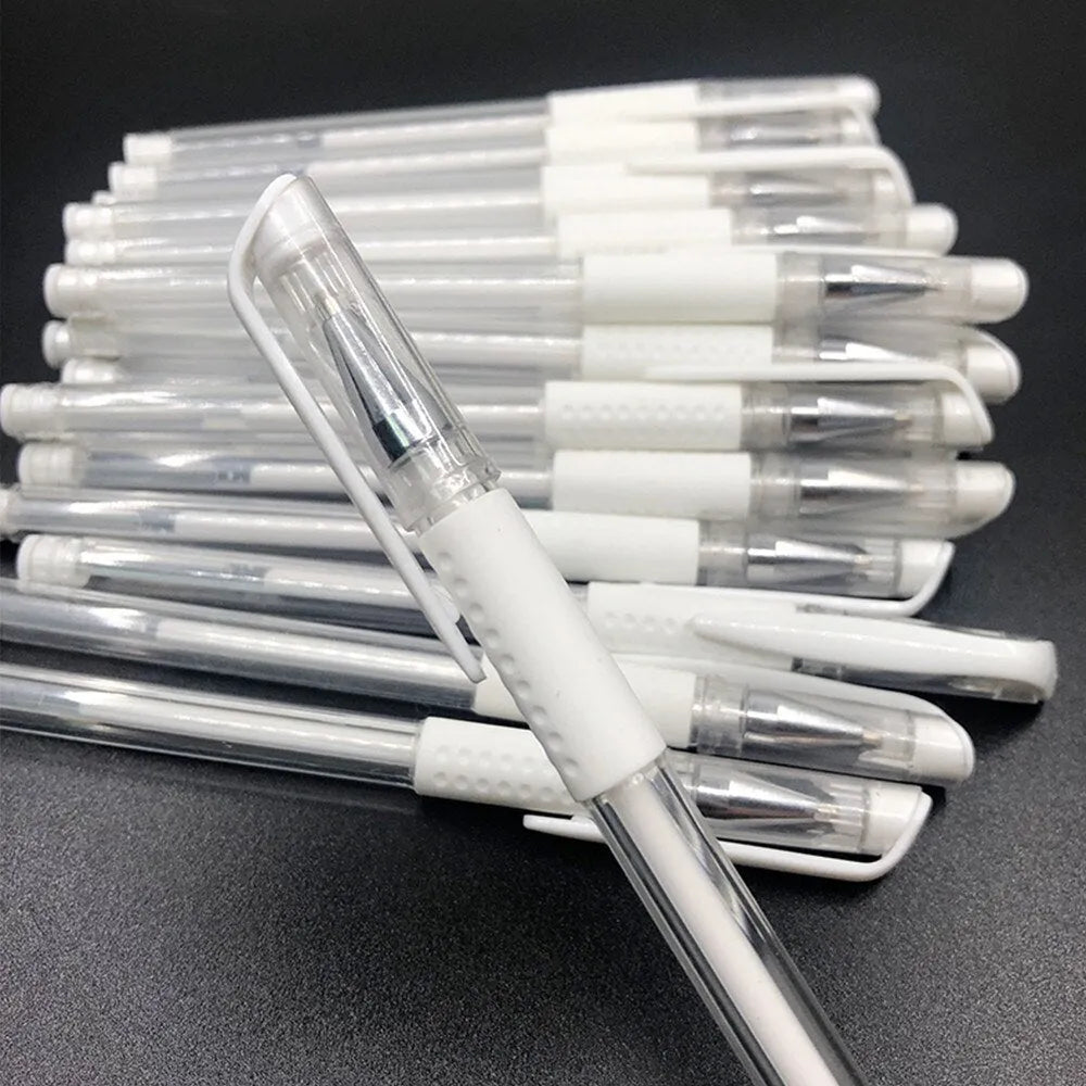 White hard pen calligraphy pen with cap closure on a dark surface showing white ink lines