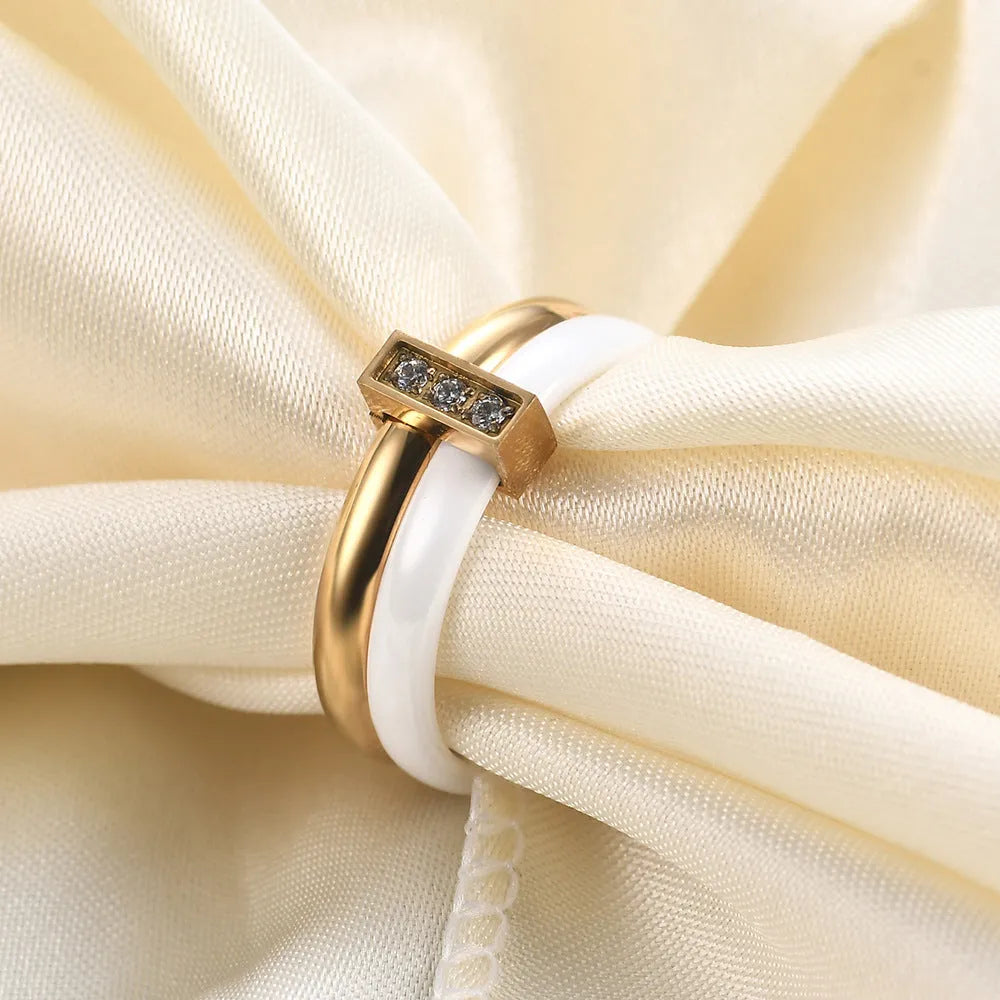 Geometric glossy ceramic women's ring with zirconium inlay, shown in steel black and gold white.