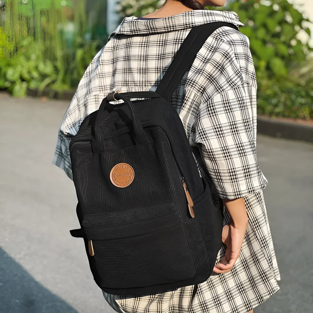 Retro unisex corduroy backpack in solid colour with breathable fabric, side view.