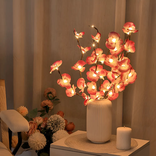 Pink silk orchid LED branch light, 65cm long, with glowing warm white LEDs on fabric petals and plastic stem.