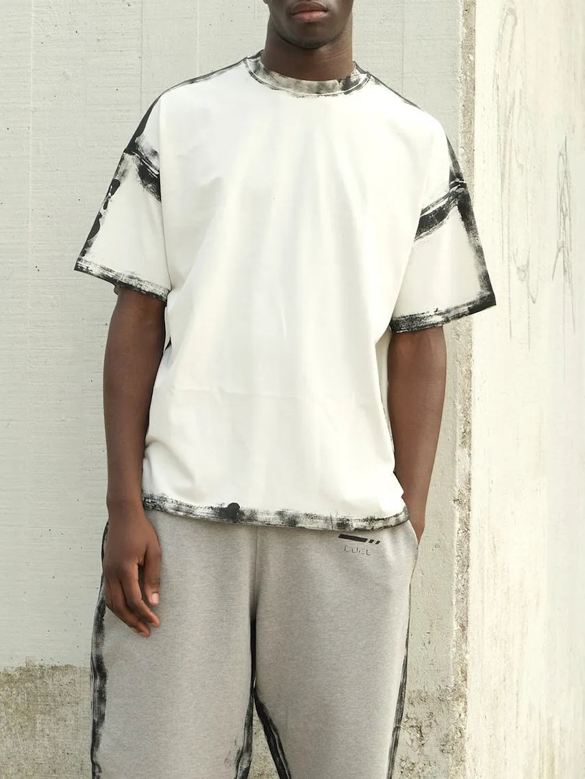 White casual short sleeve top with draped design on a hanger.