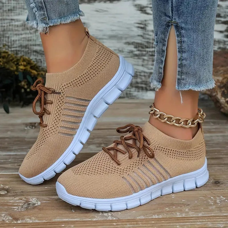 Women's casual flying knit mesh sports flat shoes in a light colour with front lace-up design.