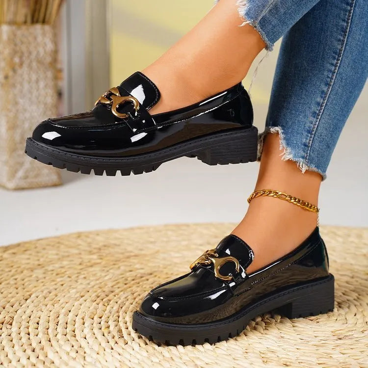 Black women's chunky heel round toe pumps with a thick rubber sole and metal detail on a white background.