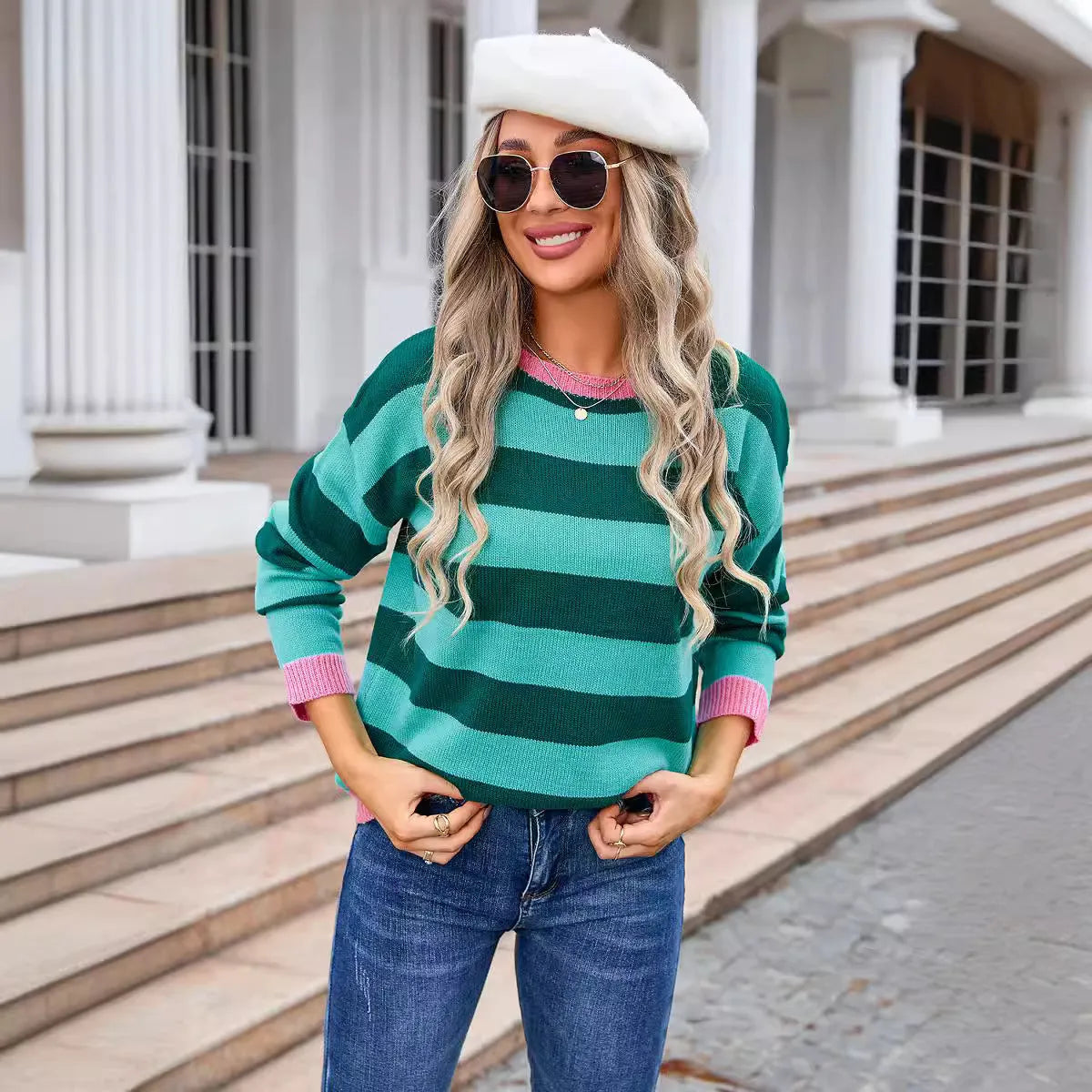 Women's loose blue acrylic sweater with long sleeves and a striped pattern on a hanger.