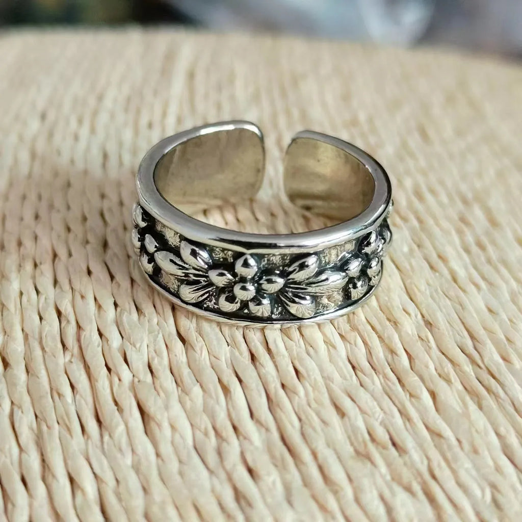 Vintage antique silver gold flower open ring with camellia design on a plain background