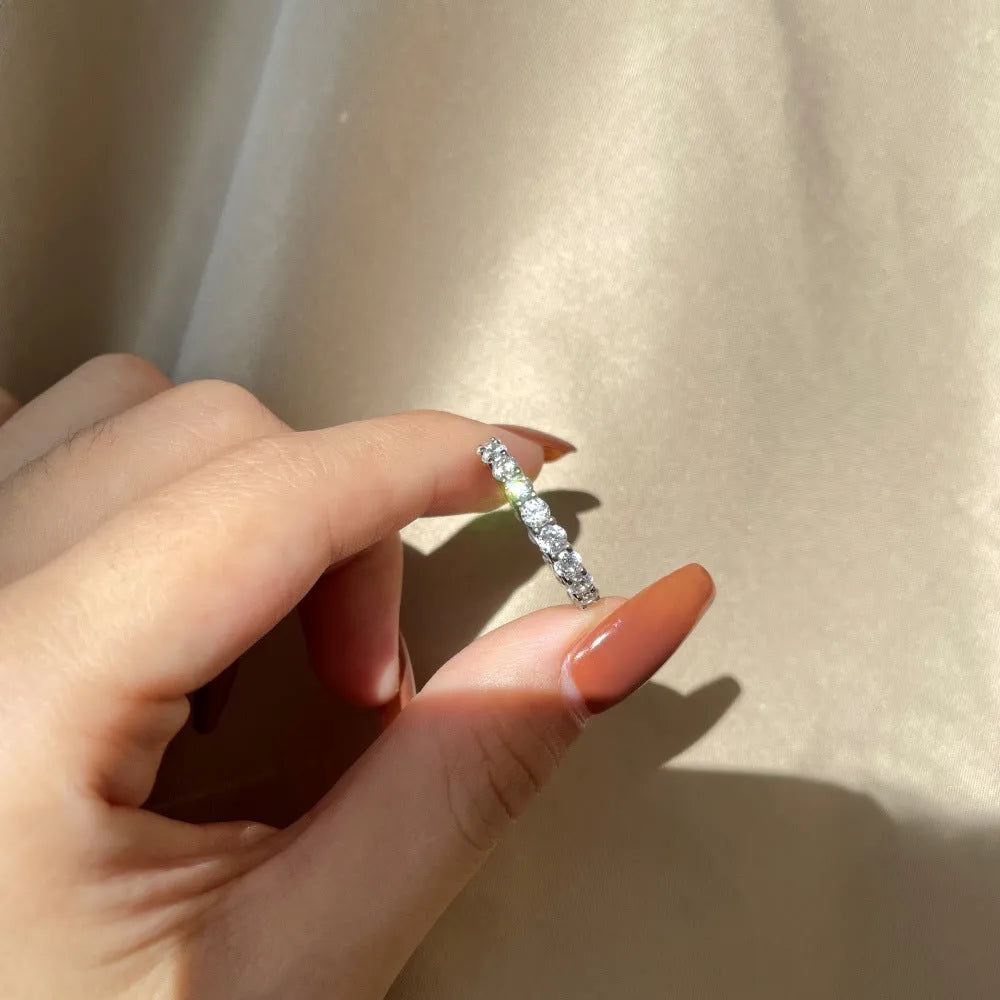 S925 sterling silver ring with geometric round design and white diamond-like stone on light background