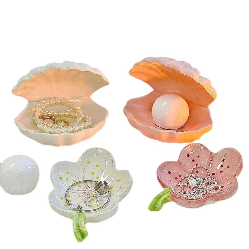 White porcelain decorative storage tray with a small built-in night light, holding jewellery on a bedside table