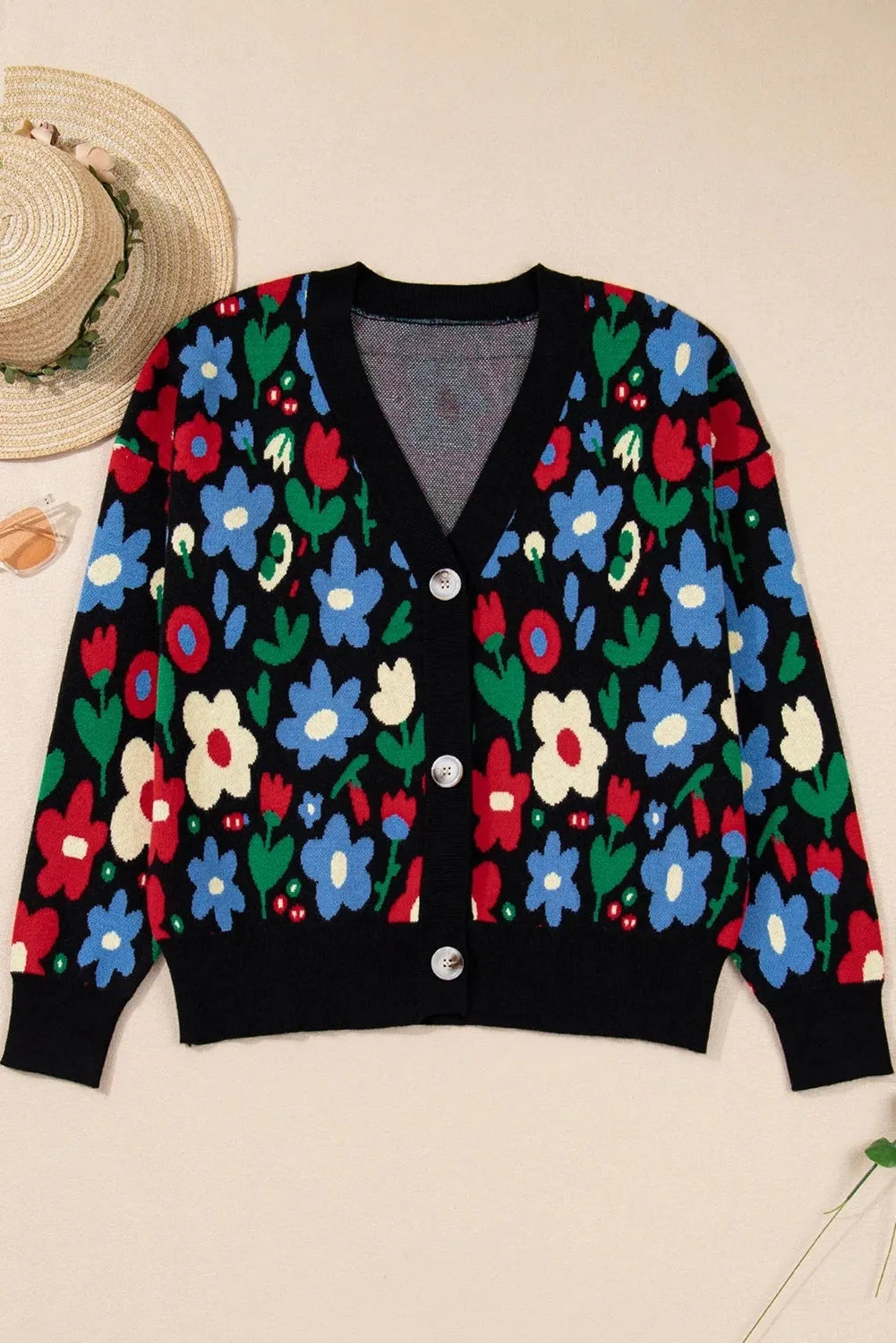 Black floral print V-neck button cardigan sweater with long sleeves and colour-block detail, laid flat