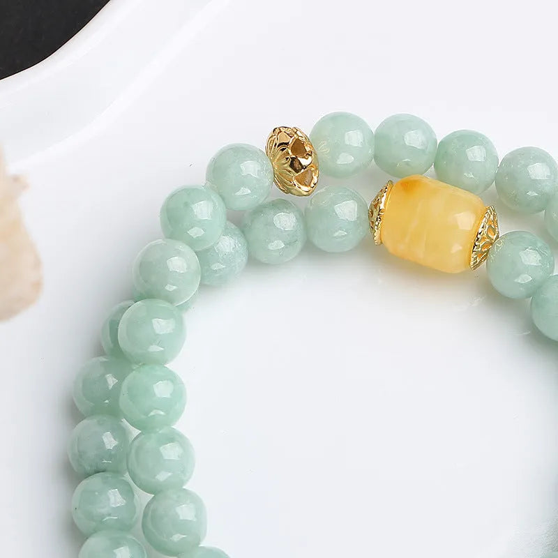 Close-up of a double-layer women's bracelet with green jade round beads and honey-coloured beeswax barrel beads.