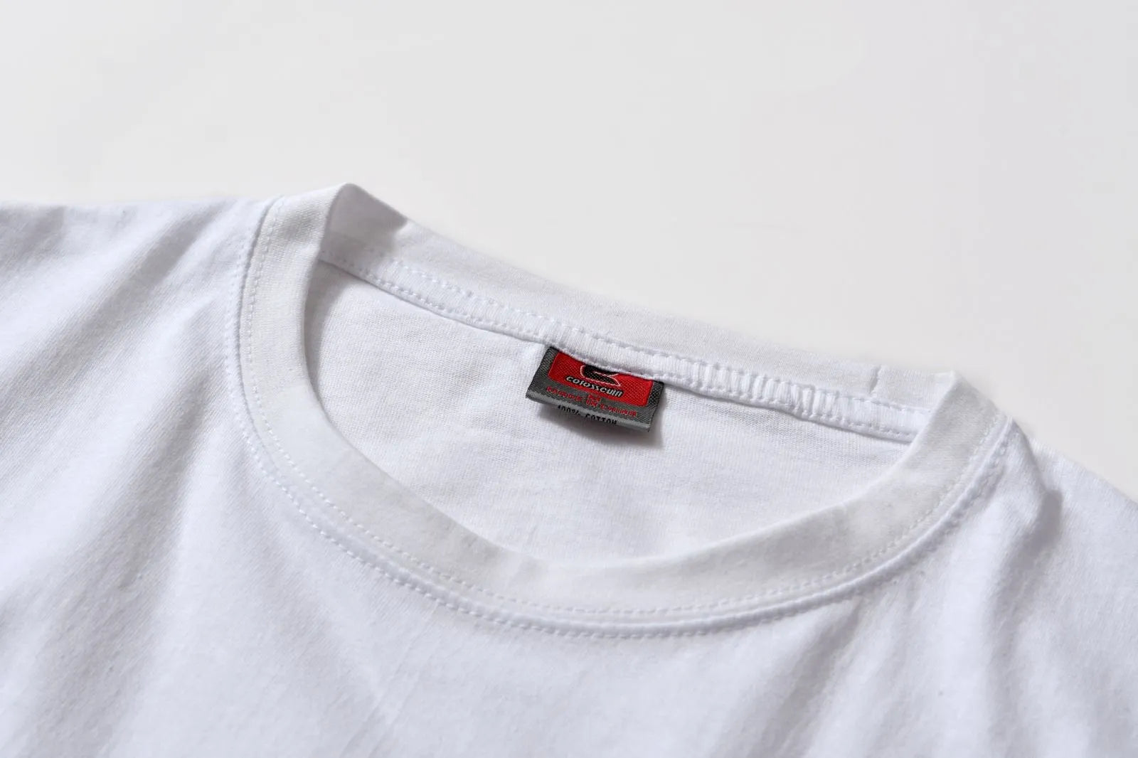 White cotton pullover overalls with short sleeves and a round neck, shown on a hanger.