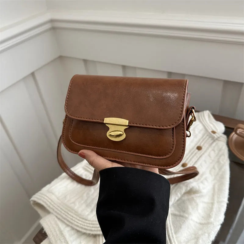 Retro-style small square handbag in soft brown PU leather with a horizontal silhouette.