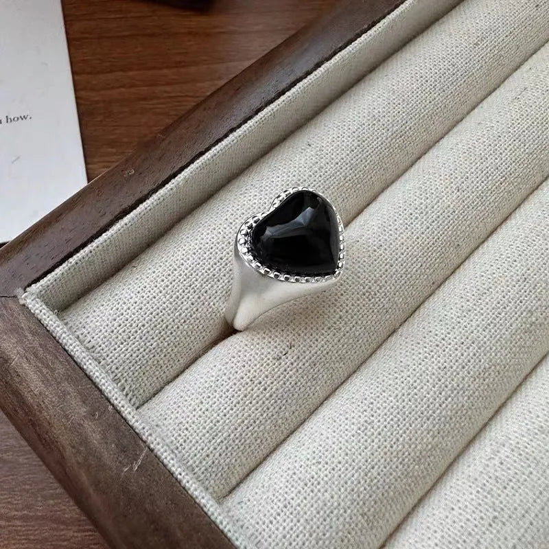 Sterling silver adjustable ring with black agate heart centrepiece on finger