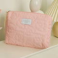 Silk quilted cosmetic bag in candy colours showing quilted texture and storage capacity