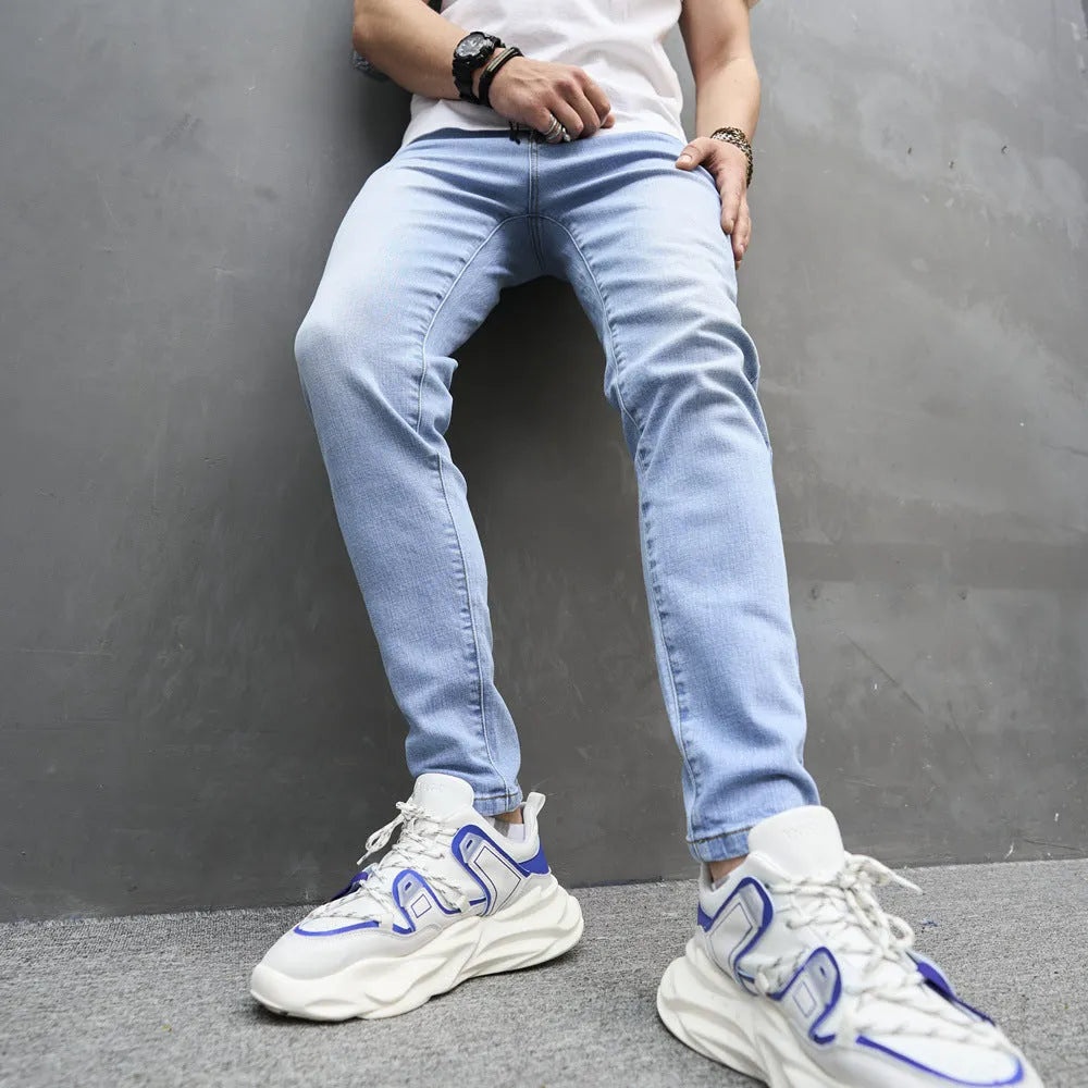 Light blue skinny cotton stretch men's jeans with mid waist and tapered leg on model
