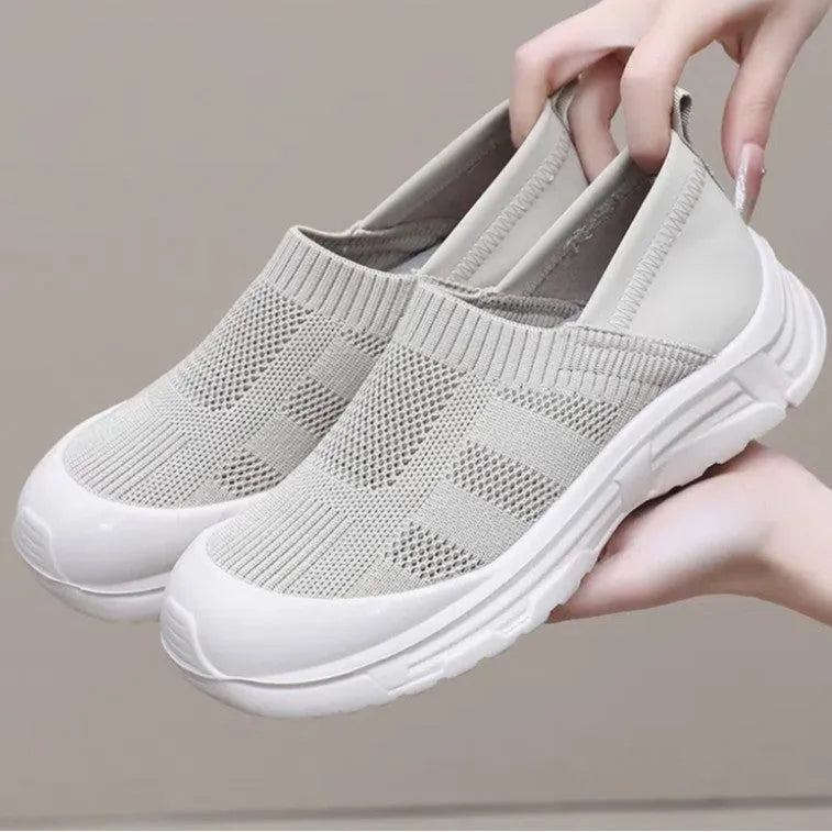 Women's black slip-on shoe with a cloth upper and soft PVC sole on a white background