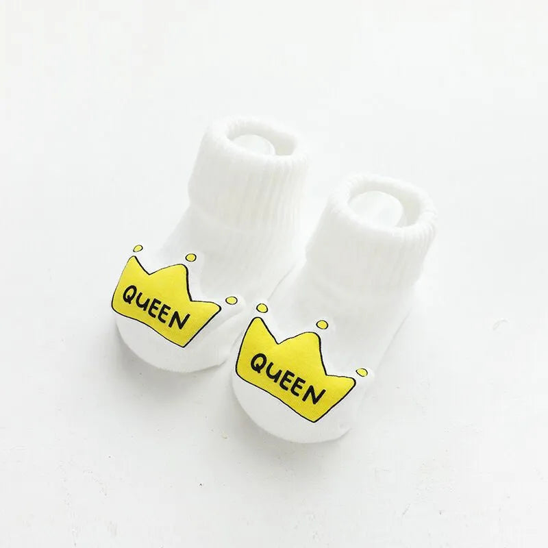 Pair of light grey baby socks with white non-slip silicone grip dots on the soles.