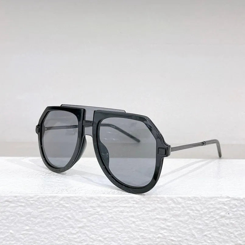 Black leopard print large frame retro sunglasses with elliptical lenses on a table next to their lens cloth and box.