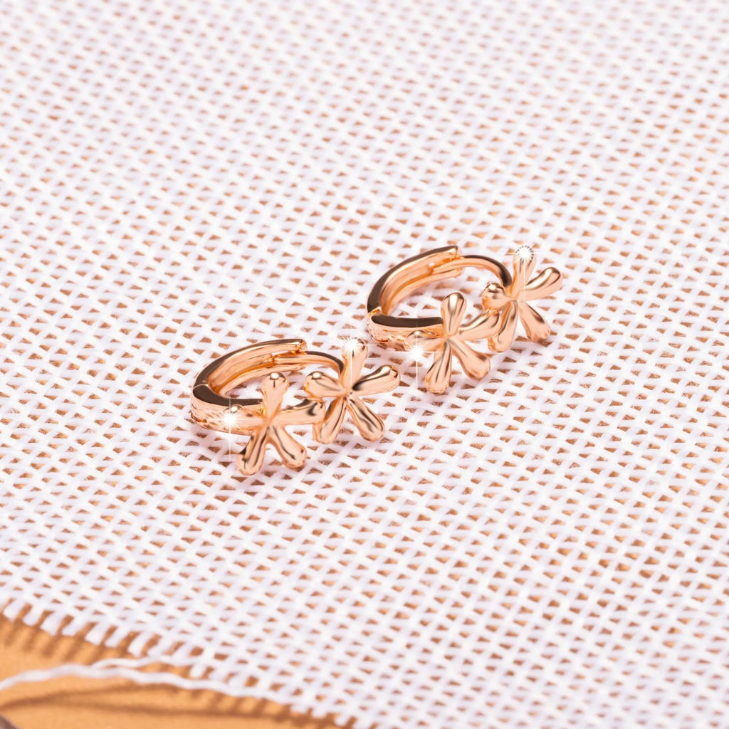 Rose gold electroplated earrings with a waterdrop shape and detailed floral petal etching on a white background.