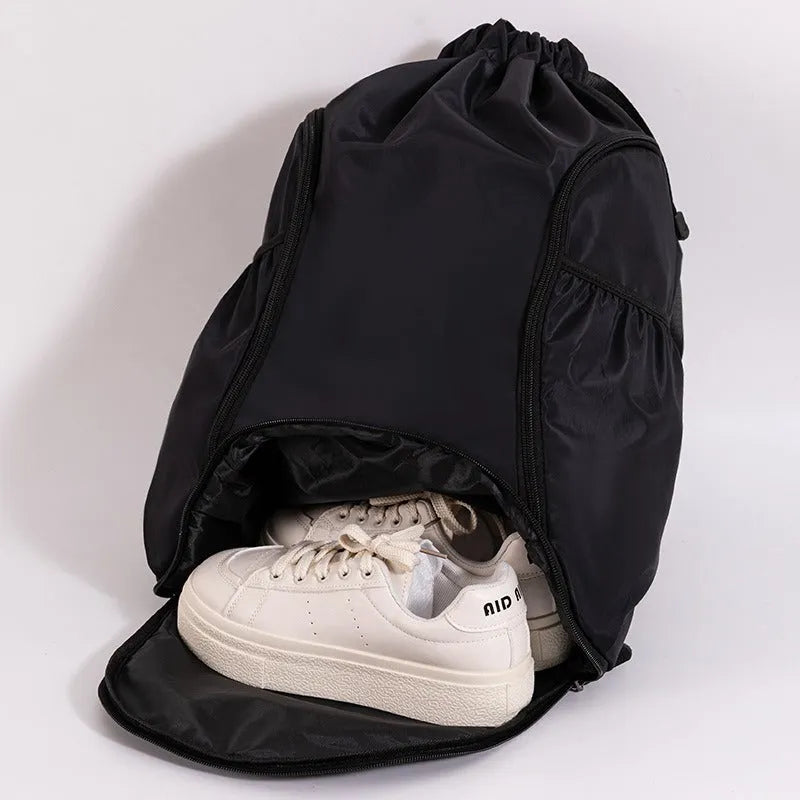 Large black cube-shaped sports backpack with a drawstring top closure, shown on a neutral background.