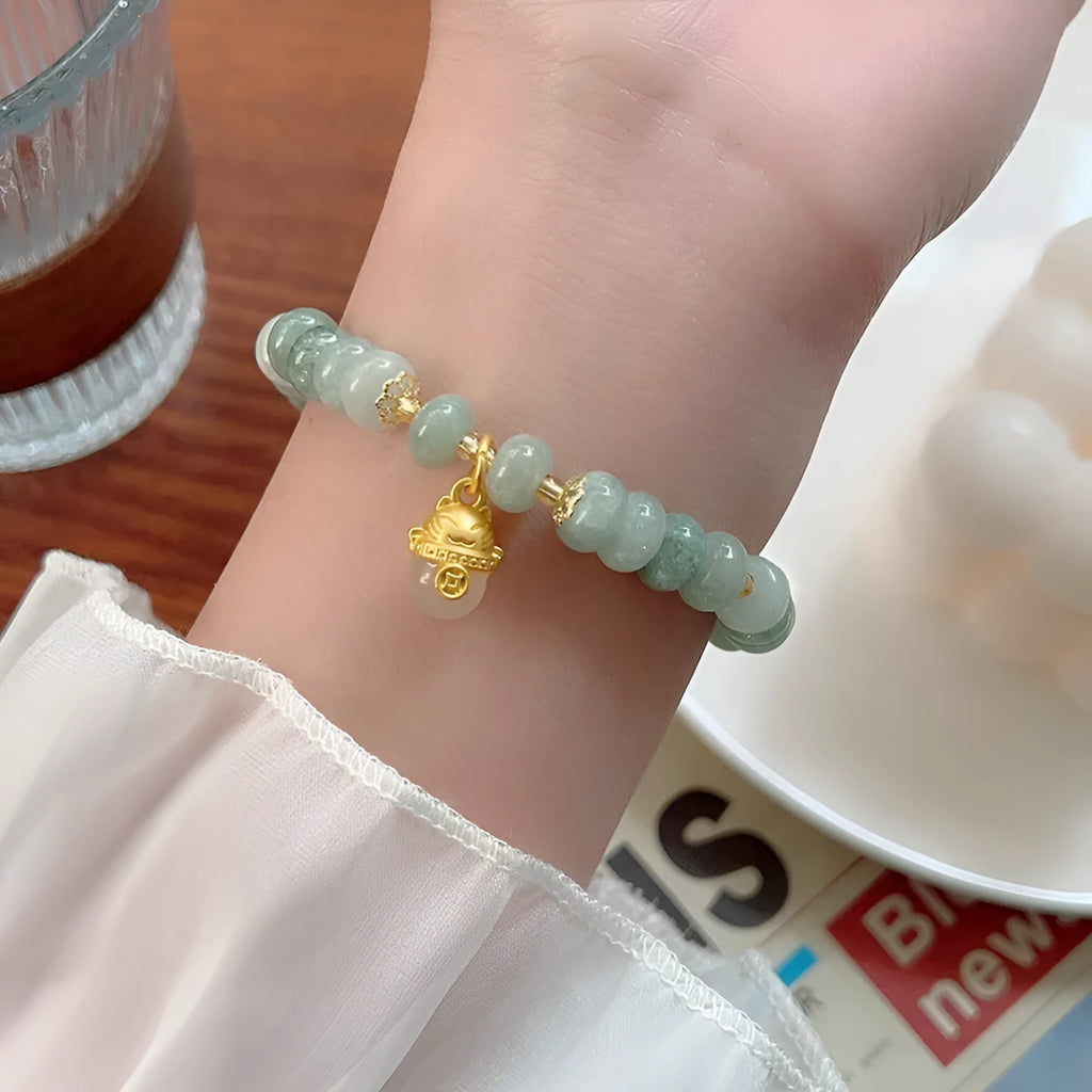 Women's retro strawberry quartz bracelet with lucky cat charm on wrist