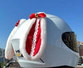 Carbon fibre rabbit ear decoration attached to a black motorcycle helmet, showing clip-on mechanism.