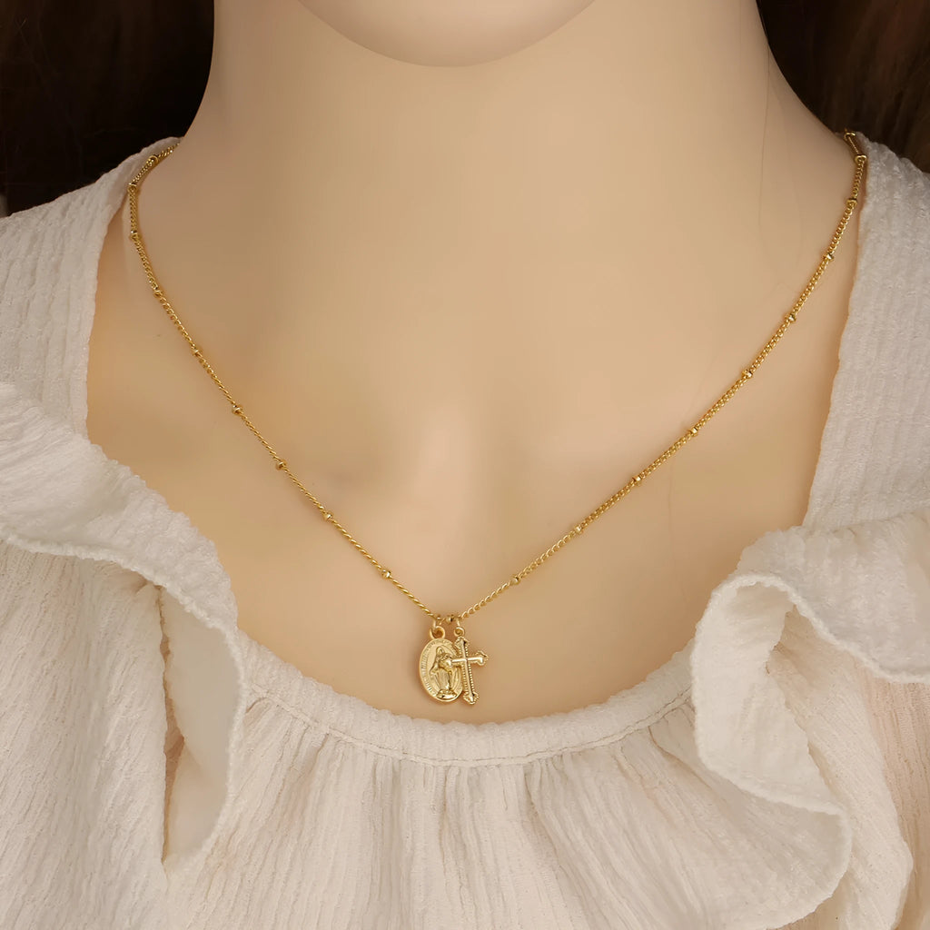 Geometric Virgin Mary cross pendant necklace in gold on a 45cm chain with lobster clasp.