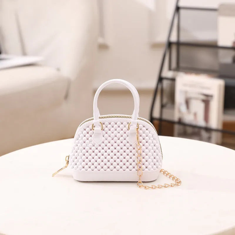 Translucent PVC jelly shell handbag with hollowed design and metal chain strap in apricot colour