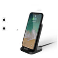 Dark grey vertical wireless charging stand for Apple phones on desktop