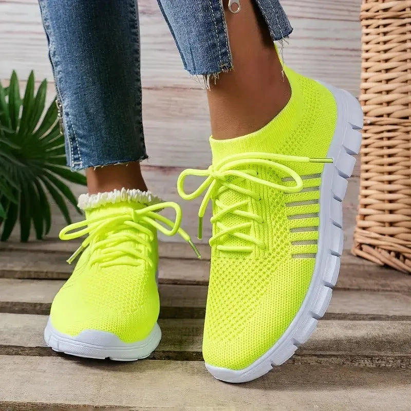 Women's casual flying knit mesh sports flat shoes in a light colour with front lace-up design.