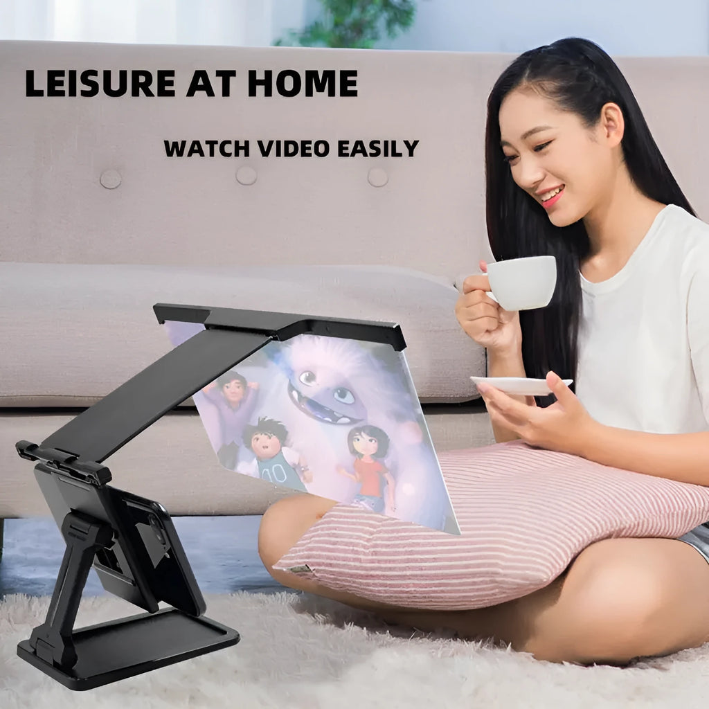 Black folding mobile phone screen magnifier and adjustable holder on a desktop.