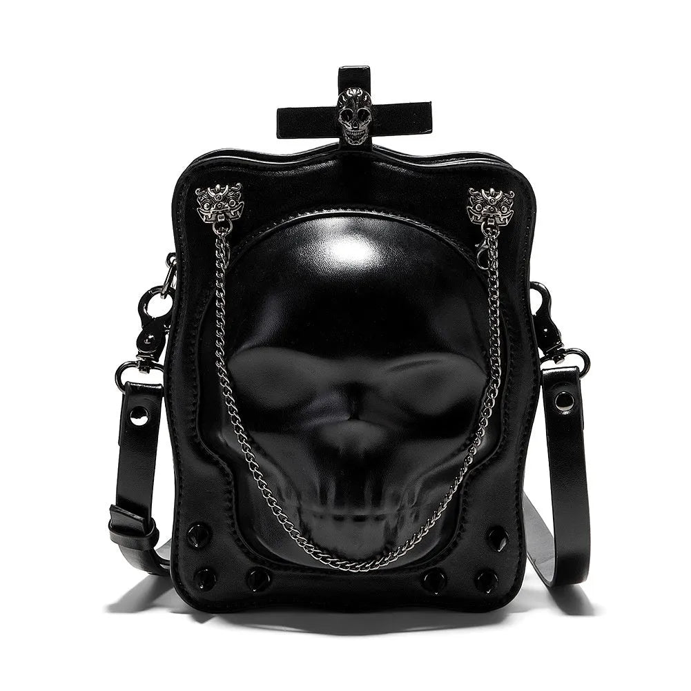 Black vertical square mini crossbody bag with embossed skull design, metal chain strap, and zipper closure