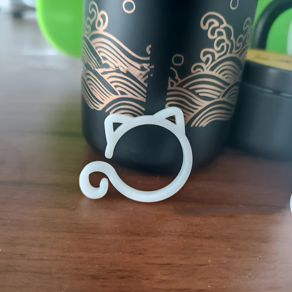Colourful cat-shaped plastic clip for plants, shown in red, yellow, green, and white options.