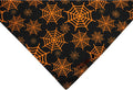 Reversible Halloween dog bandana with pumpkin and spider web patterns in black and orange