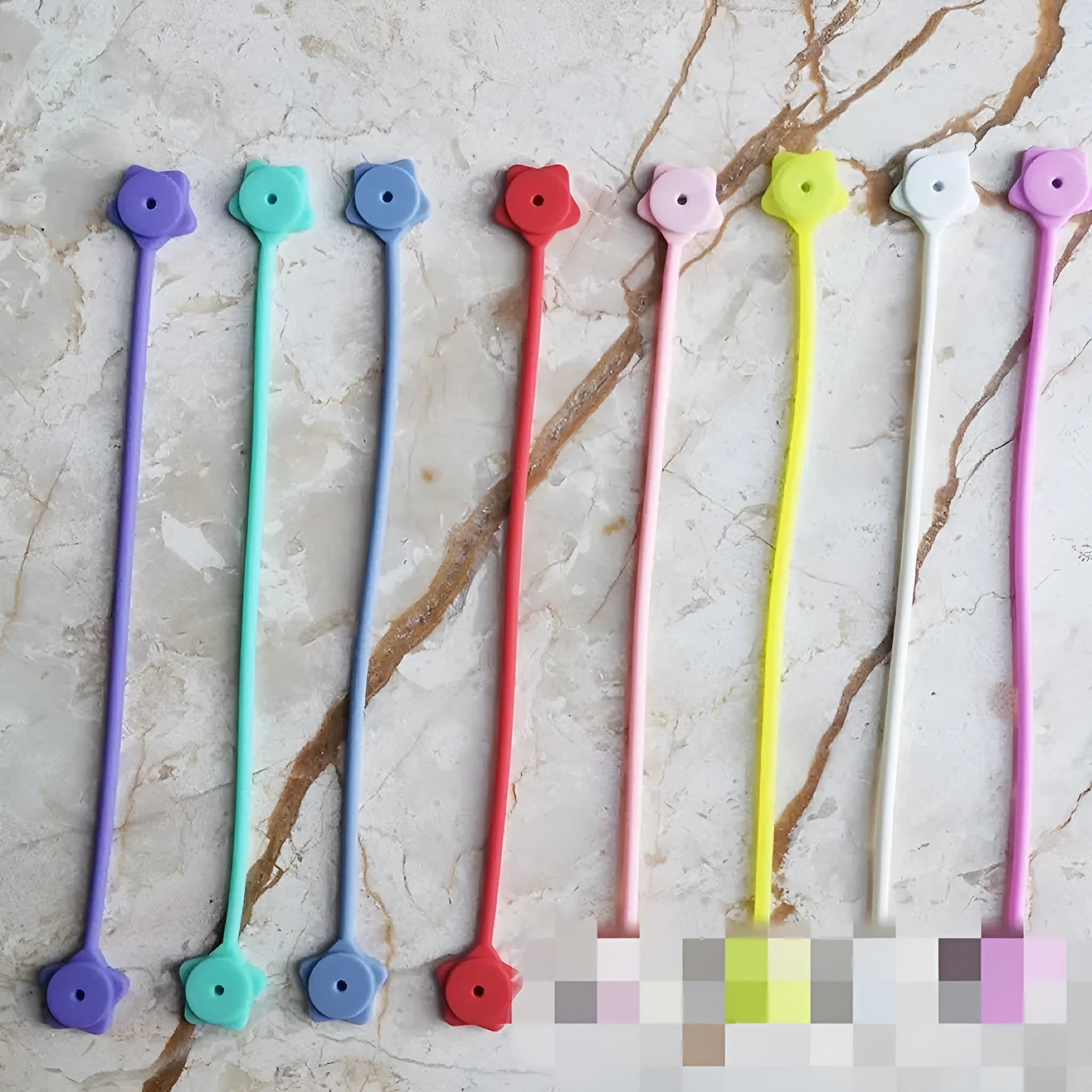 Purple silicone wire winder with magnet holding a coiled white headphone cable.