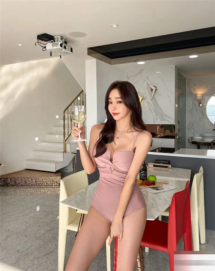 Simple solid colour one-piece swimsuit with spaghetti straps and push-up design in white, pink, or brown.