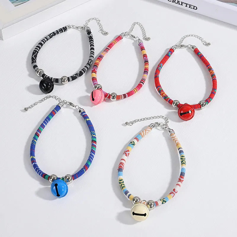 Coloured ethnic style pet collar with a metal bell on a cat or small dog