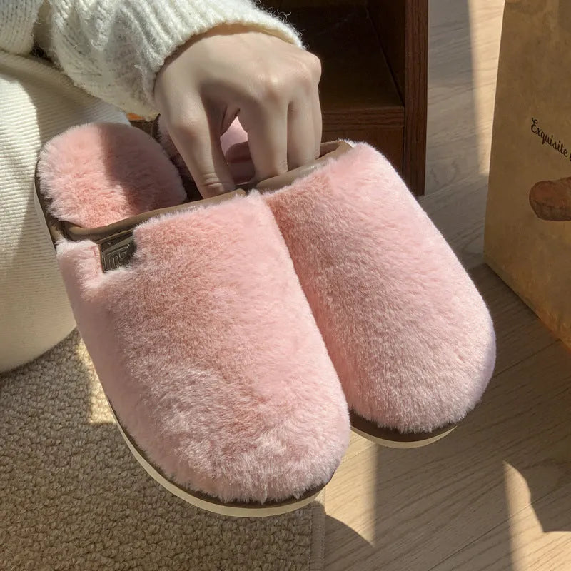 Pair of solid-colour plush winter slippers with a PVC upper and textured non-slip sole.