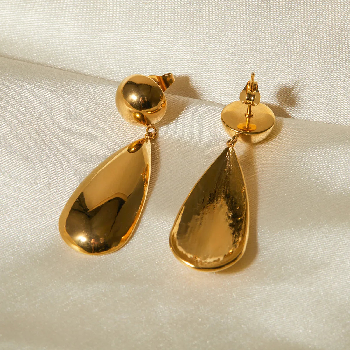 Gold geometric hemisphere water drop pendant earrings made from stainless steel.