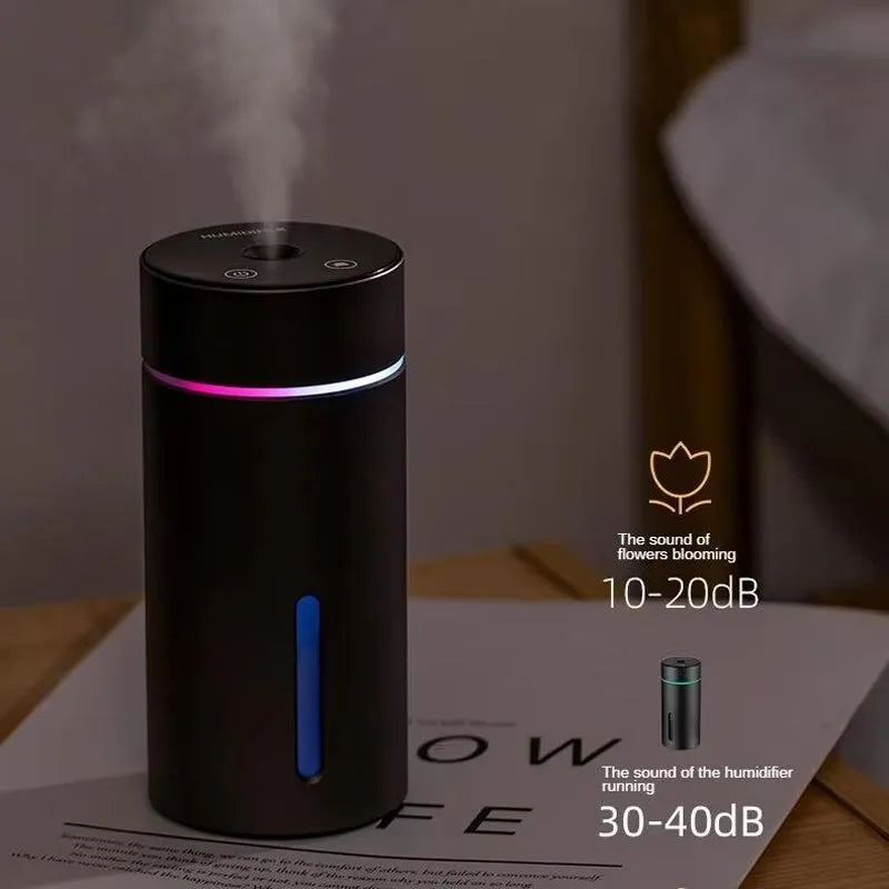 Black aluminium portable car humidifier and essential oil diffuser with USB cable on a desk.