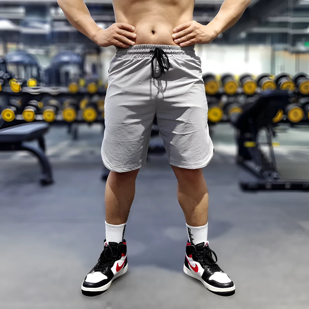 Men's thin quick-drying running shorts in black, blue, or grey on a hanger.