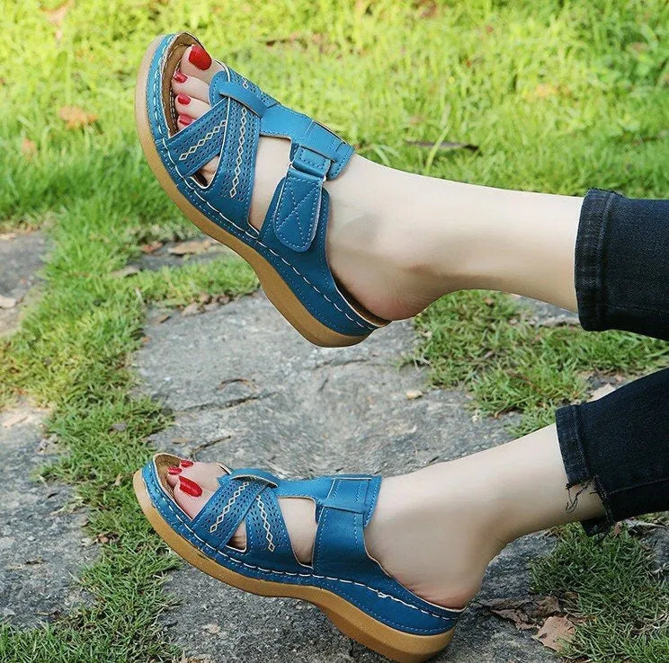 Women's red peep toe wedge sandals with a velcro strap closure on a fish mouth hollow wedge heel.