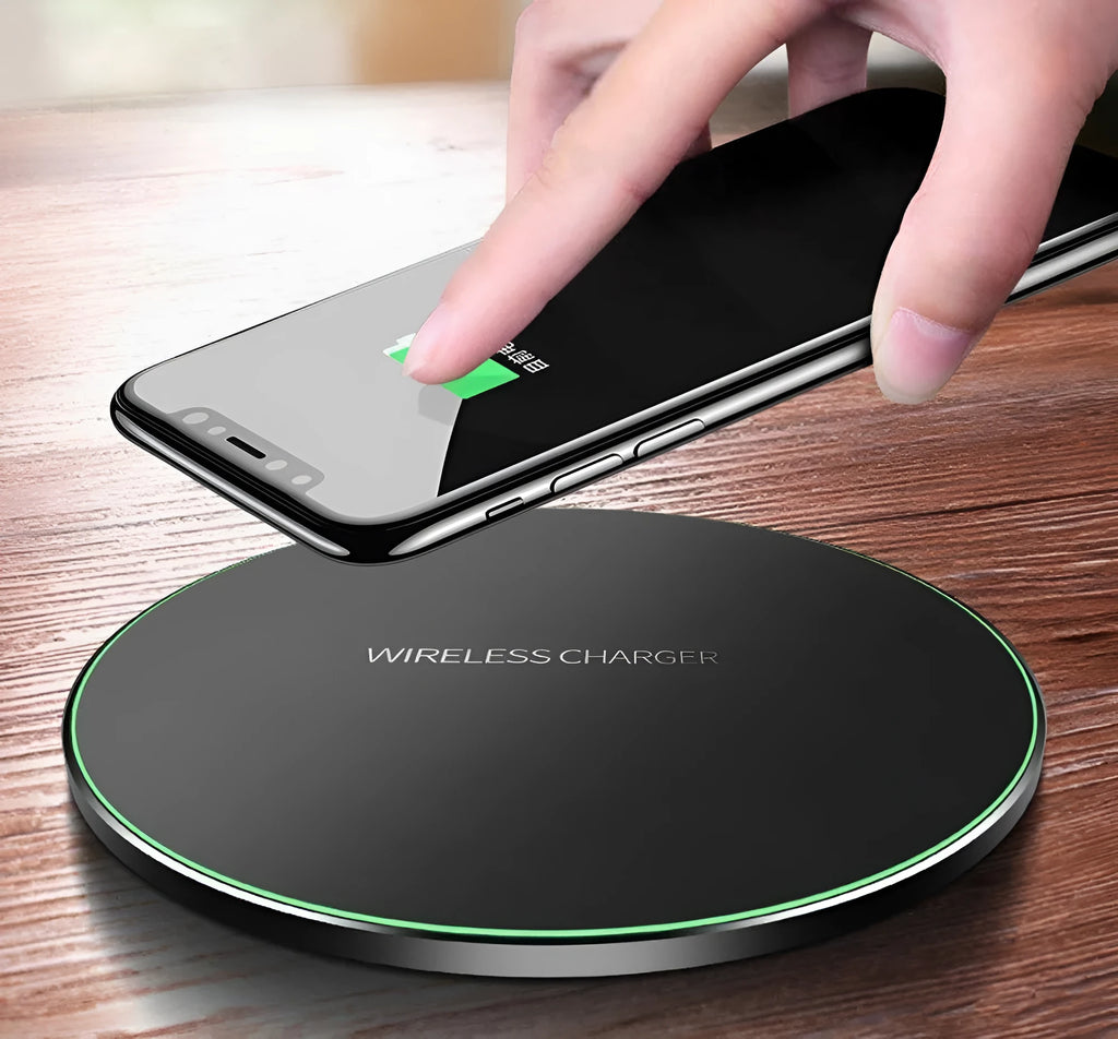 Black square wireless charging pad on desk with smartphone charging wirelessly