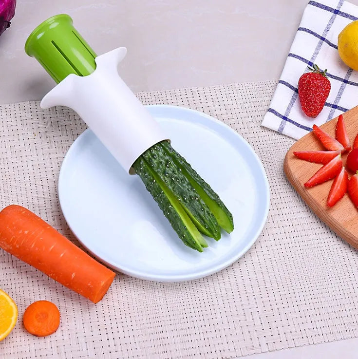 White handheld vegetable cutter with multiple stainless steel blades for slicing cucumbers, carrots, and strawberries.