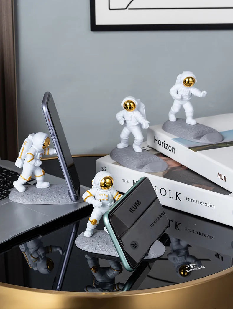 Astronaut decoration spaceman plastic mobile phone holder in blue, gold, and silver colours for lazy binge-watching