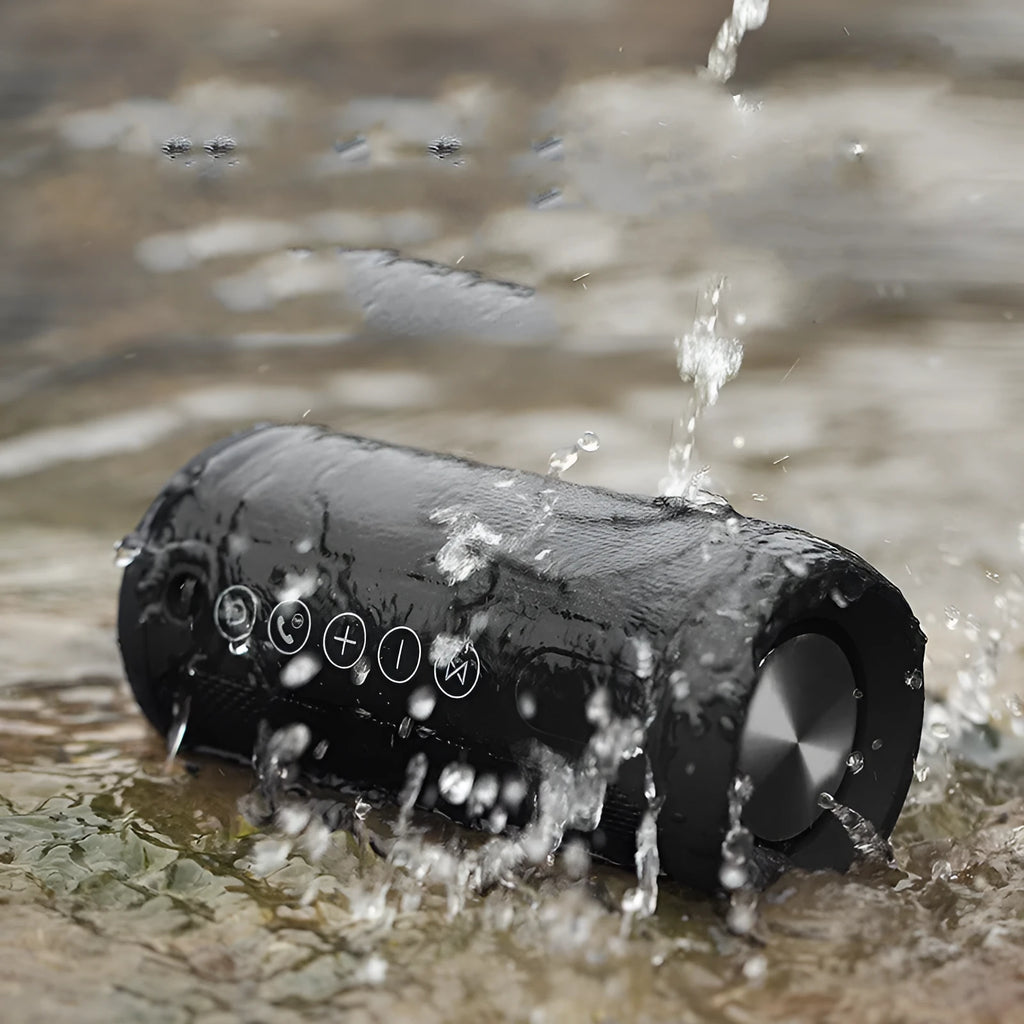 Compact flat waterproof Bluetooth speaker in black, showing its portable card-like design and control buttons.